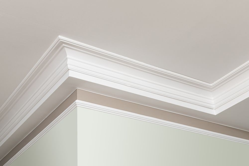 White crown molding along a beige room corner near the ceiling