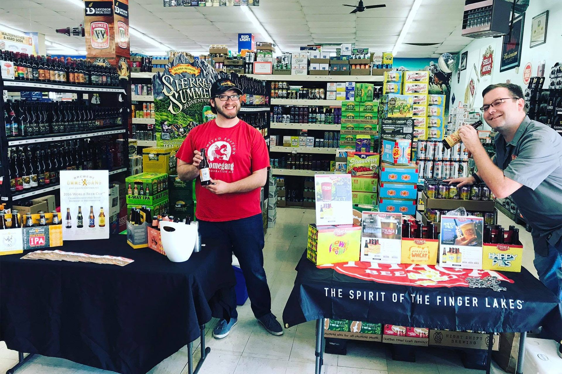 Two people at a bookstore display table with board games and books in a store aisle