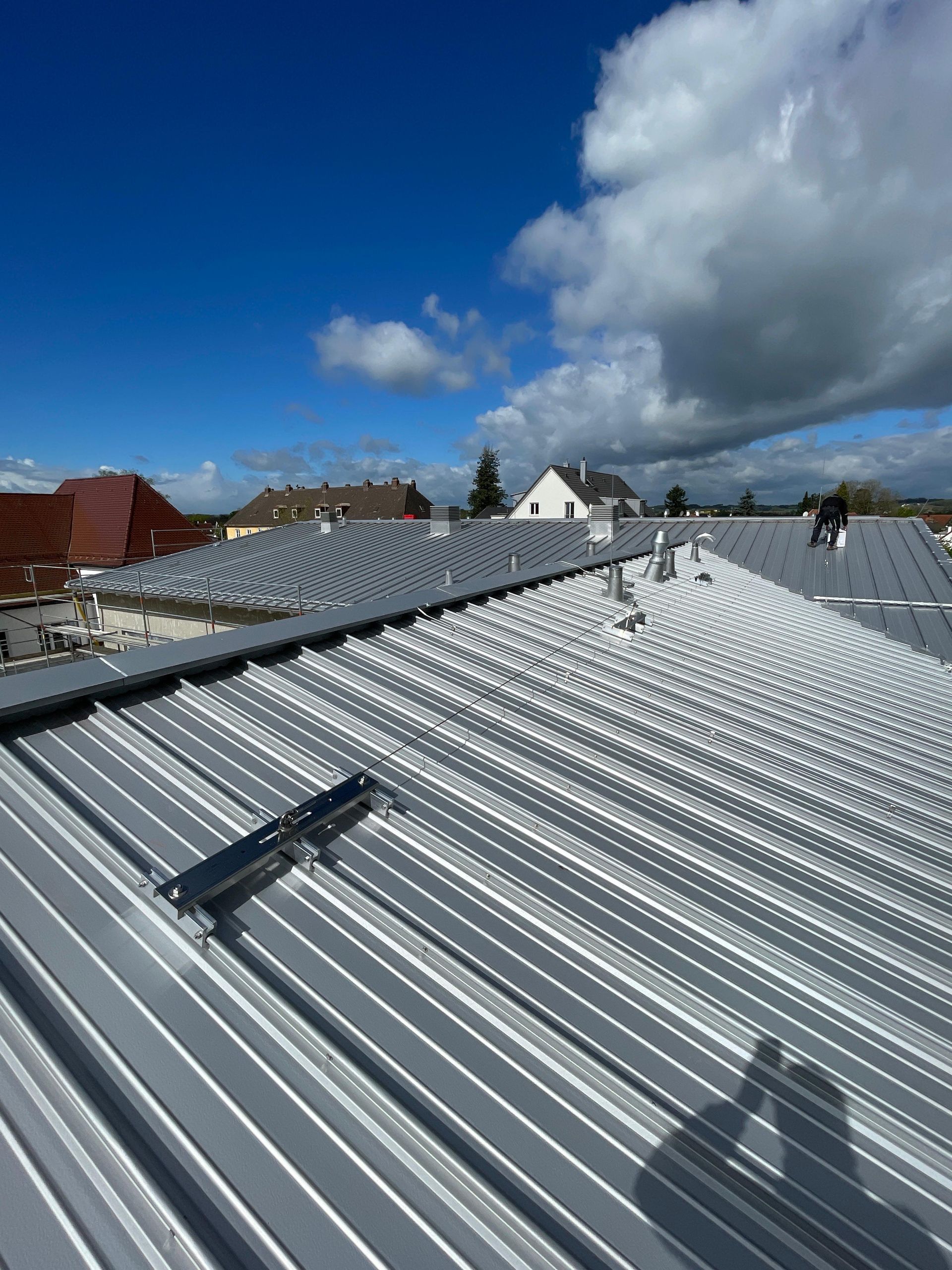 Ein Metalldach mit blauem Himmel und Wolken im Hintergrund