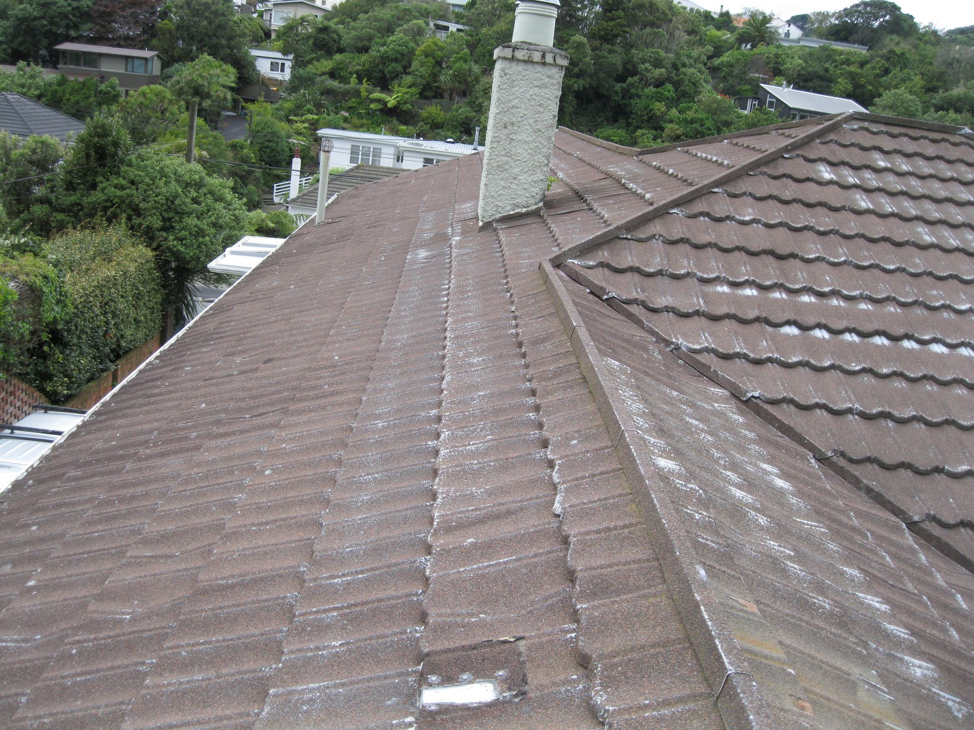 The roof of a house with a chimney on it.