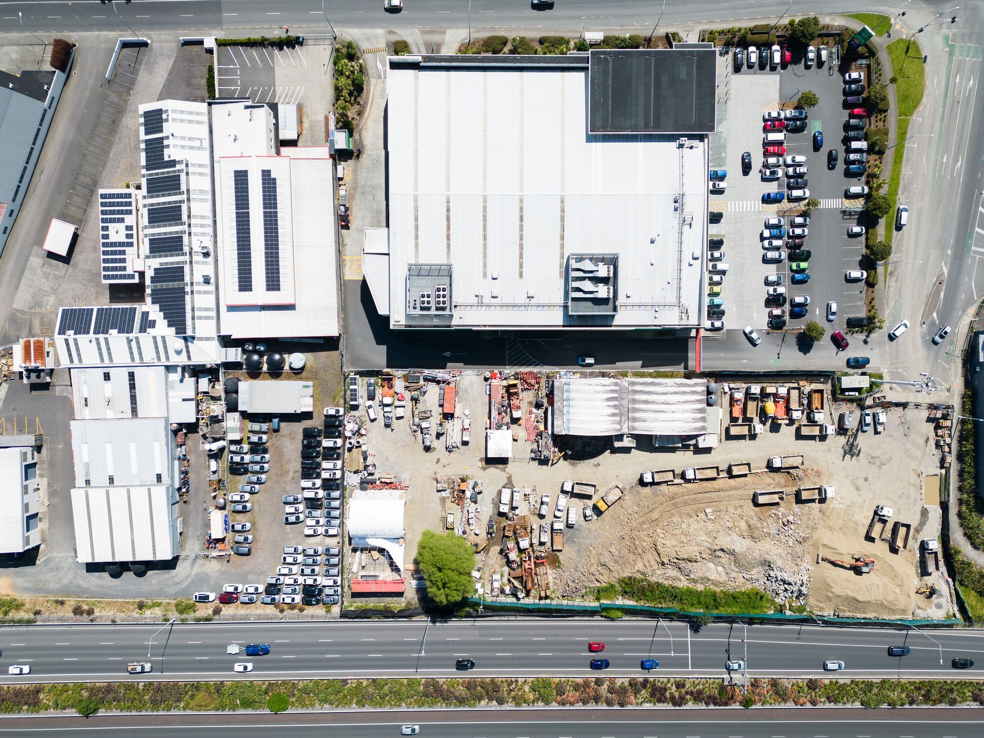 An aerial view of a large building with a lot of cars parked in front of it