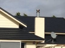 A house with a chimney and satellite dish on the roof.