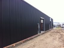 A large black building with a lot of windows is being built.