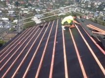 A man is working on the roof of a building.