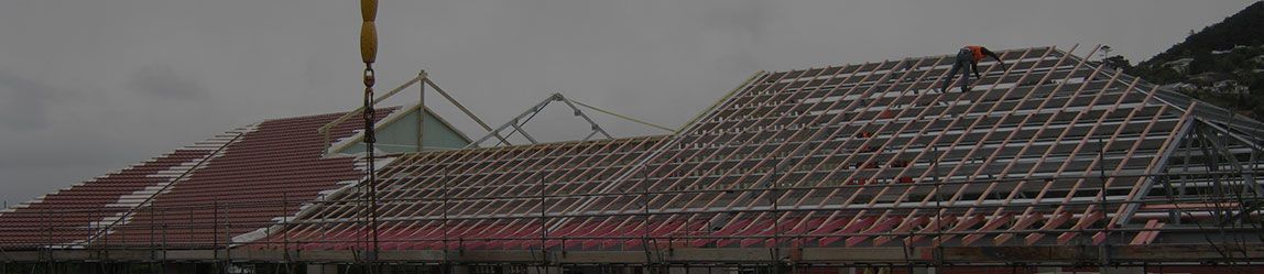 A blurred image of a building under construction with a flag in the foreground.