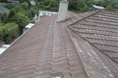 The roof of a house with a chimney on it.