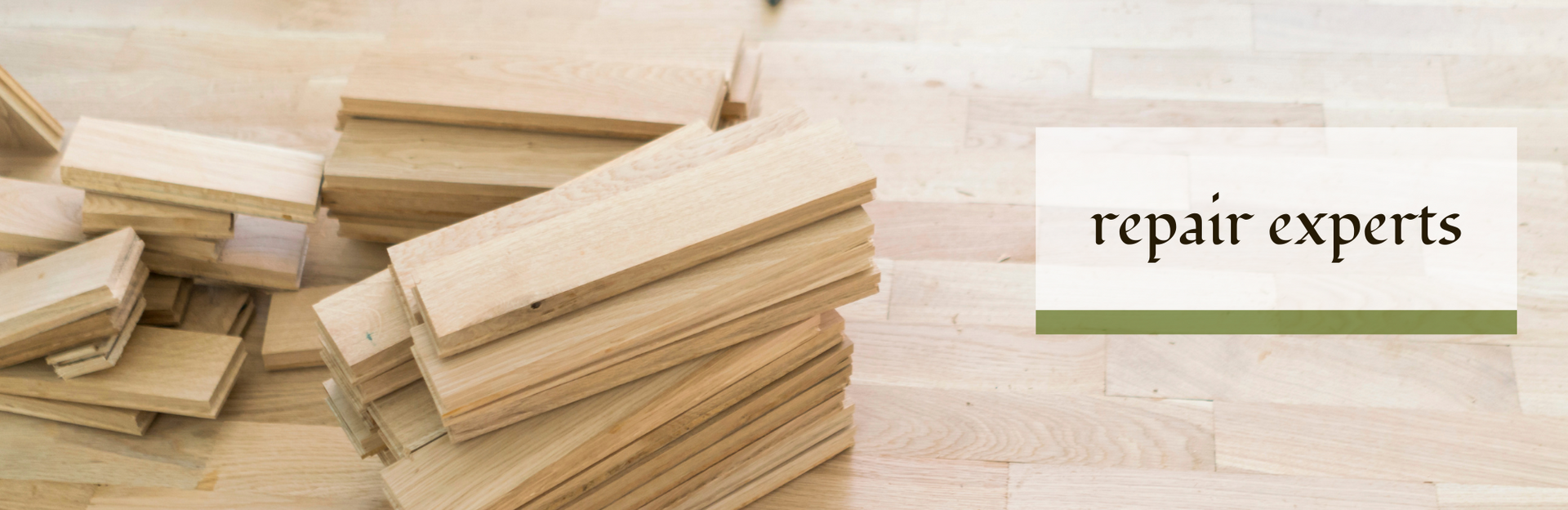 A stack of light-colored wooden floor planks sits on a wood floor next to a label that reads