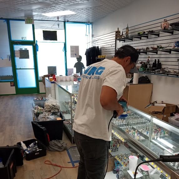 Man working on a display case inside a store with products.