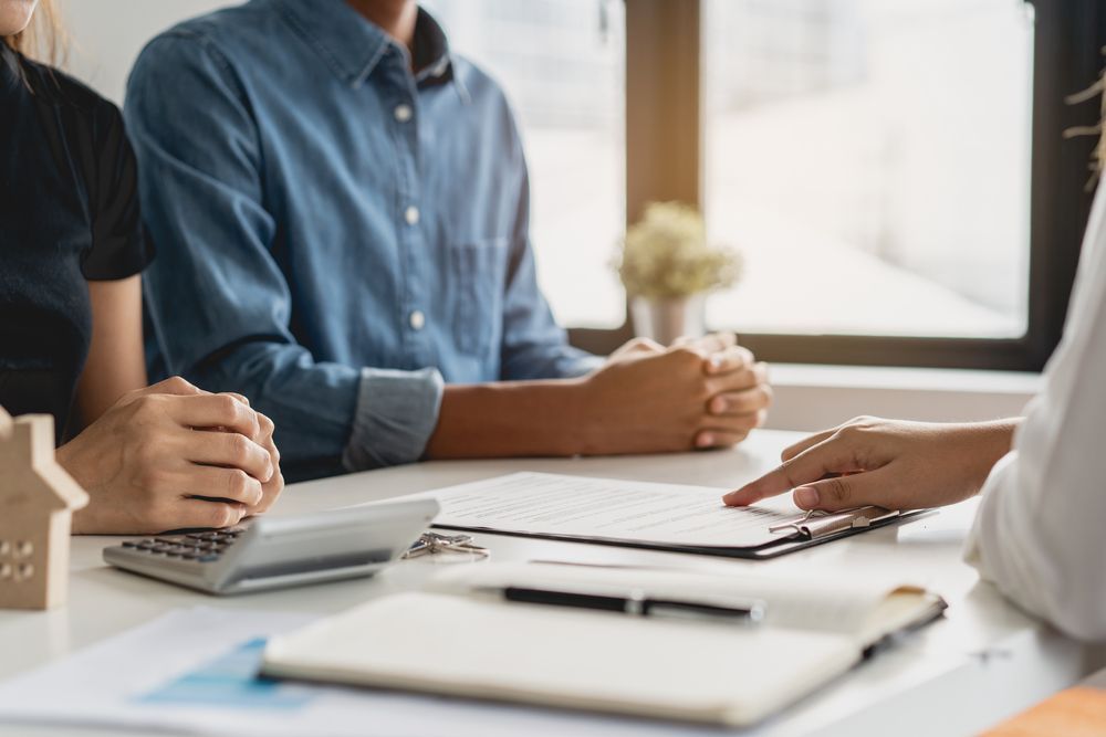 People in a meeting signing documents at a bright office table