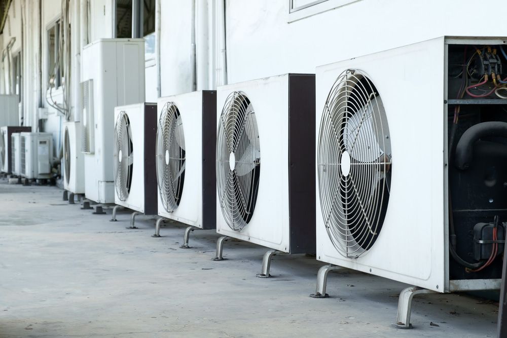 A Row of Air Conditioners Are Lined Up Outside of a Building — Rabbit Electrical Service In Armidale, NSW