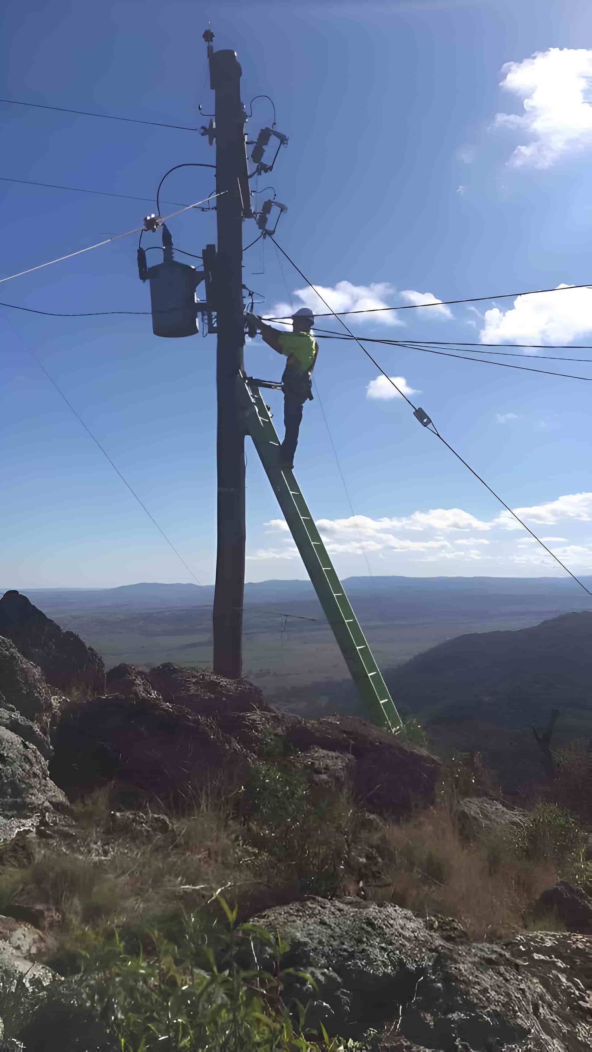 A Utility Worker Climbs a Green Ladder to Repair a Power Line — Rabbit Electrical Service In Taminda, NSW