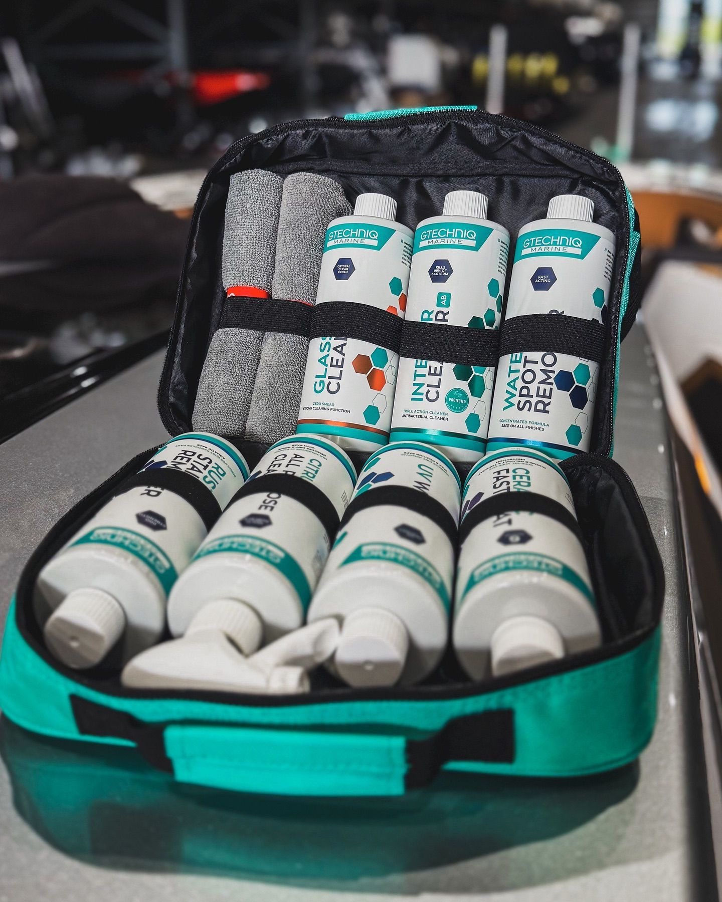 Open teal travel case holding assorted white and gray supplement bottles and packets