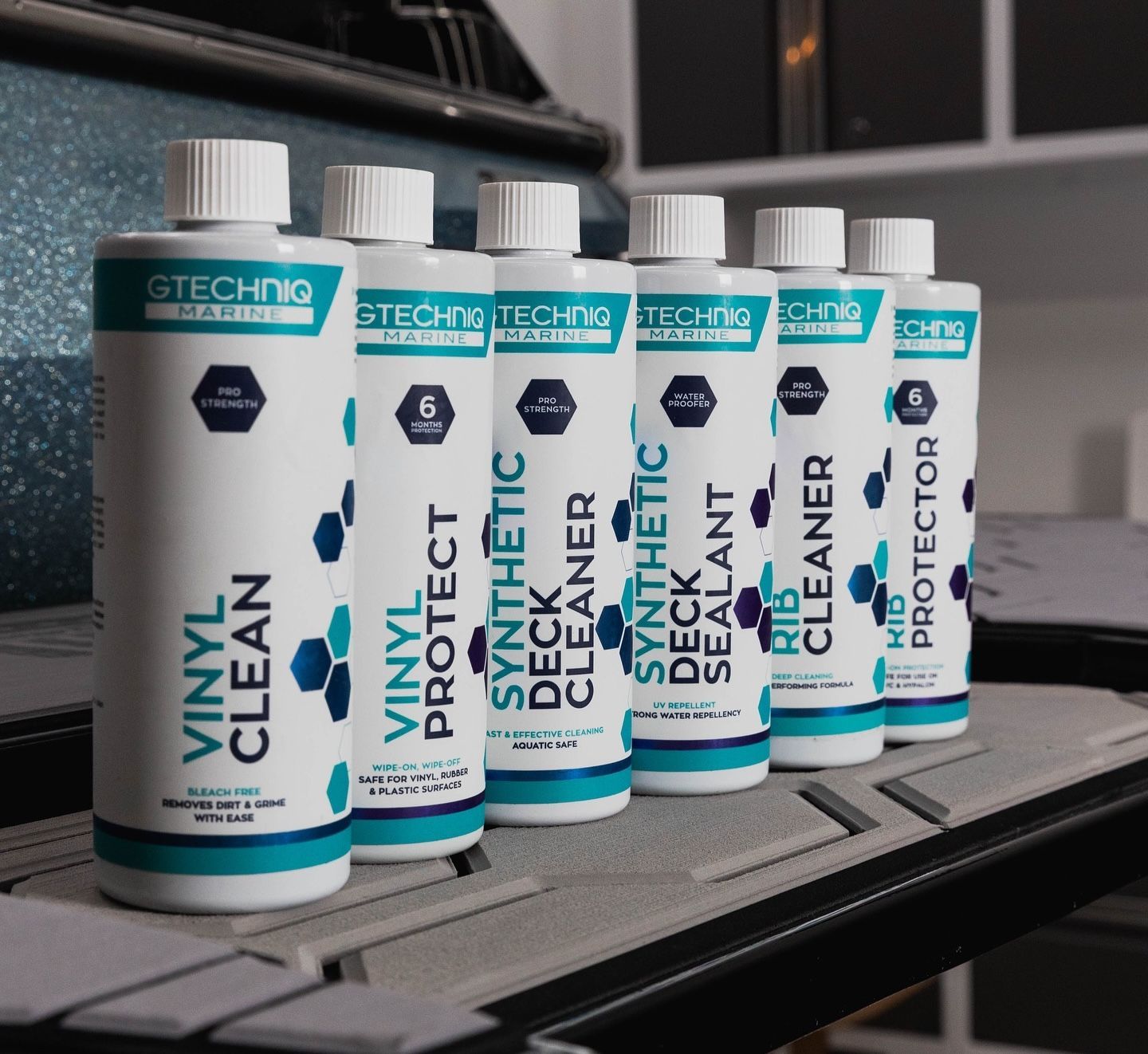 Row of teal-and-white Technic cleaning product bottles on a shelf or workbench