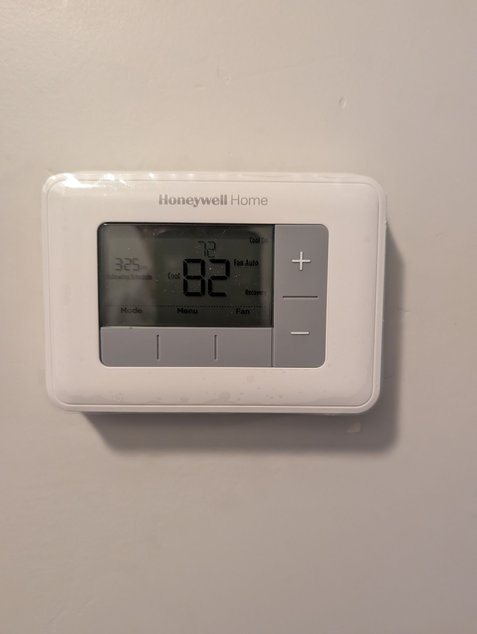 Wall-mounted Honeywell thermostat showing 82° on a beige wall