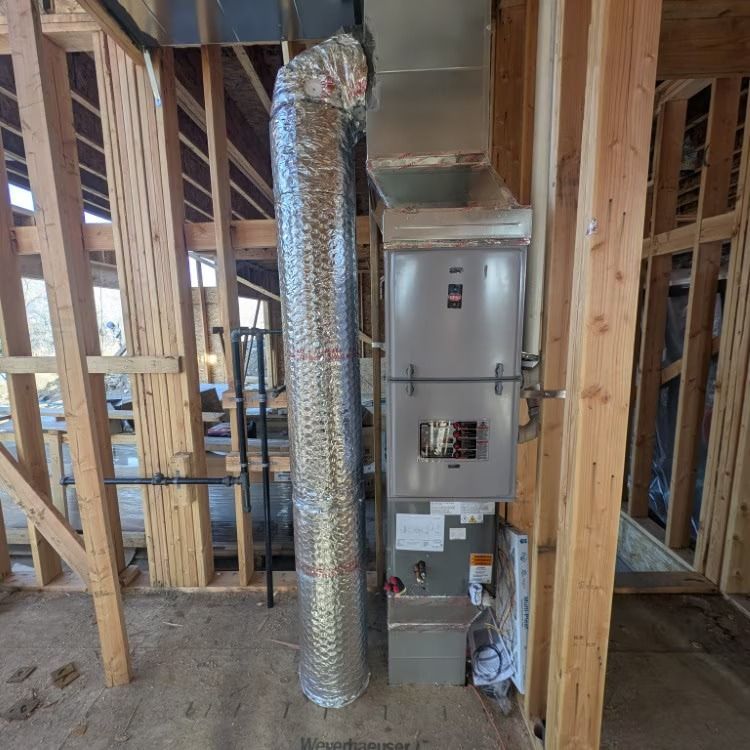Framed house interior with HVAC ductwork and furnace installed against unfinished wood studs