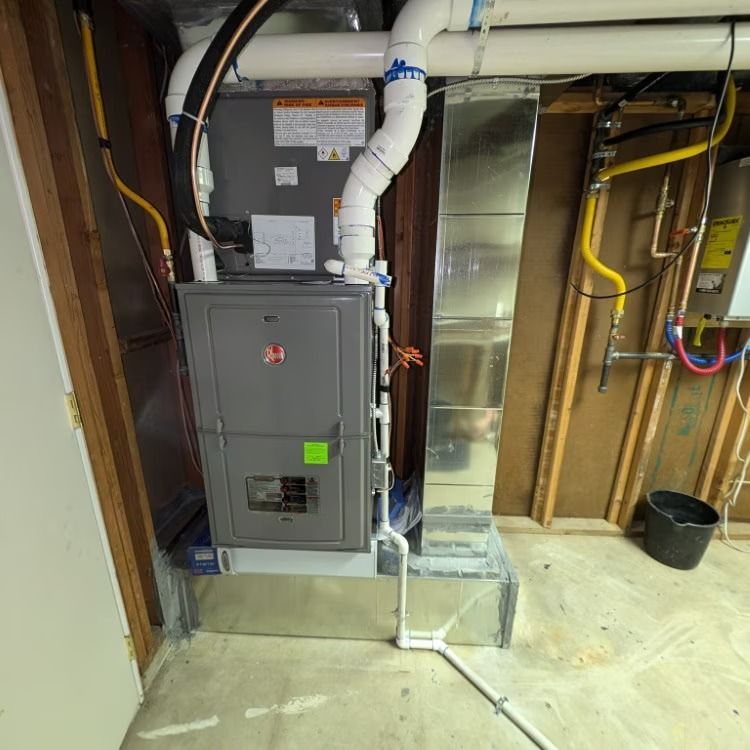 Basement HVAC furnace with white ductwork and exposed utility wiring in an unfinished room