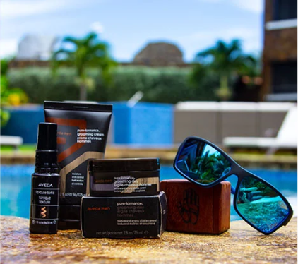 Skincare products and blue sunglasses on a poolside table with a blurred resort background