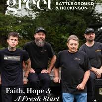 Four people stand outdoors in black shirts 