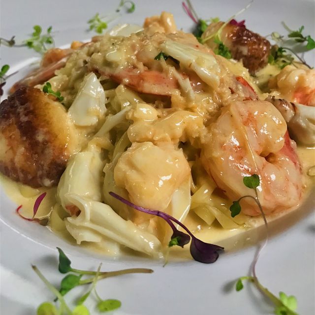 A close up of a plate of food with shrimp and noodles