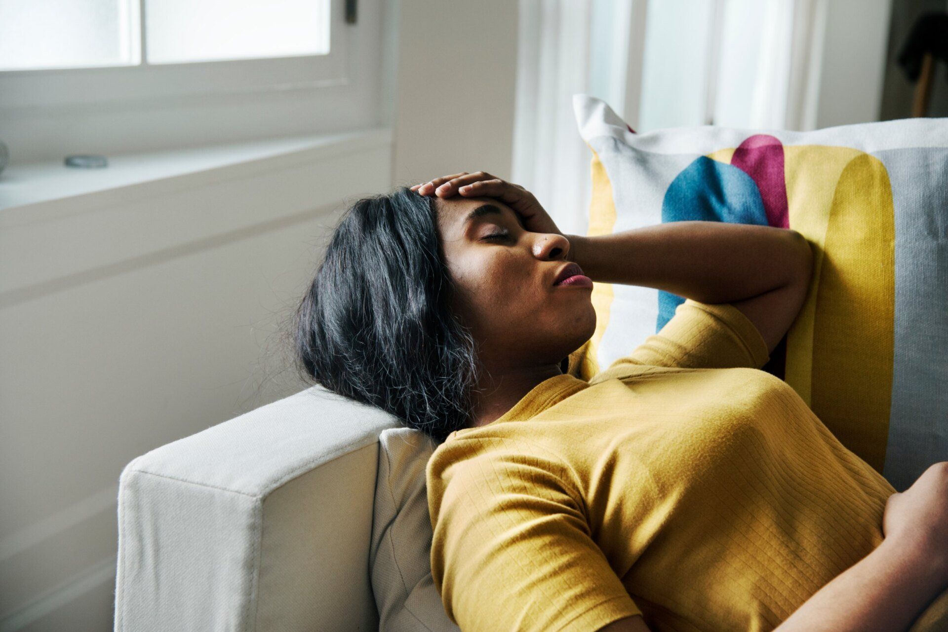 young black woman touching forehead feeling ill