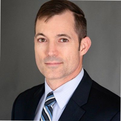 A man in a suit and tie is smiling for the camera. A man in a suit and tie is smiling for the camera.