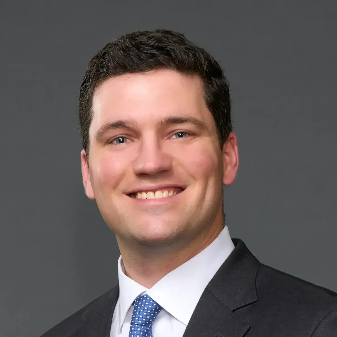 A man in a suit and tie is smiling for the camera. A man in a suit and tie is smiling for the camera.