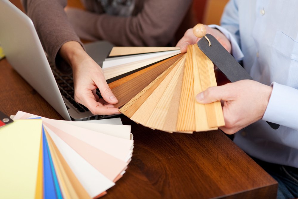 Couple looking at Timber Flooring Swatches — Flooring Suppliers in Laurieton, NSW