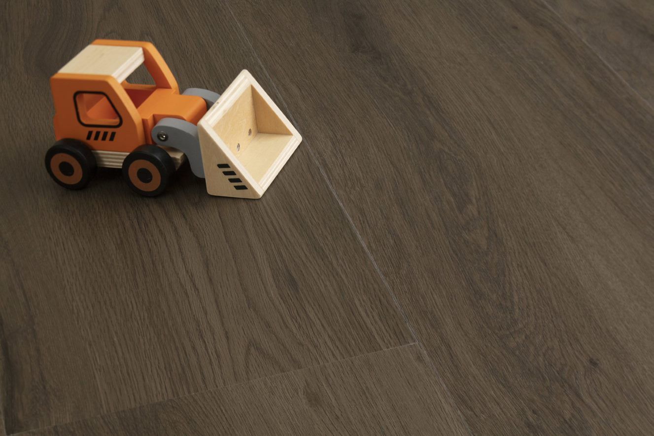 A Toy Bulldozer is Sitting on a Wooden Floor — Flooring Suppliers in Port Macquarie, NSW
