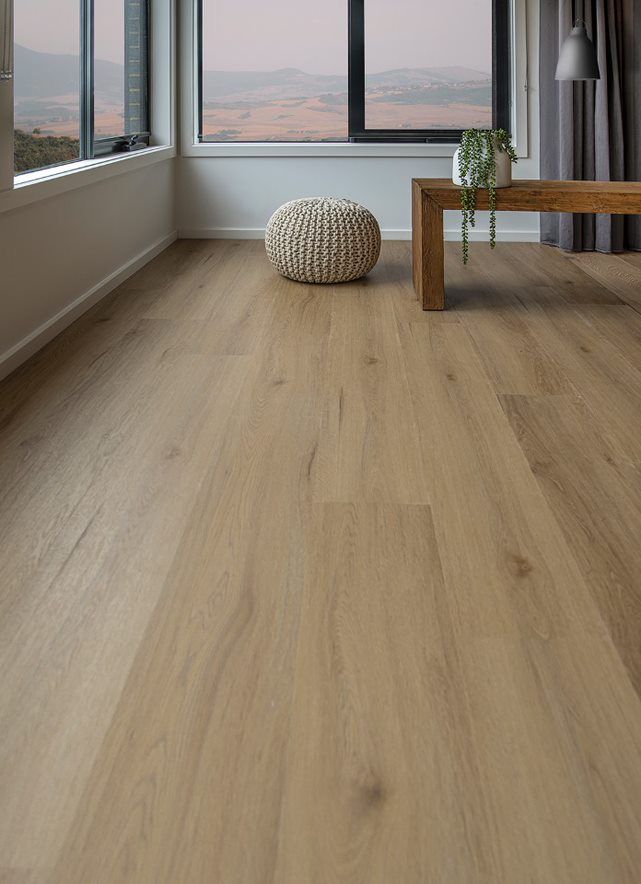 A Living Room With Hardwood Floors, A Coffee Table with a Plant on It, And A Large Window — Flooring Suppliers in Port Macquarie, NSW