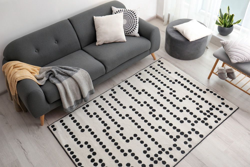 Grey couch and dotted white carpet design — Floor Coverings in Taree, NSW