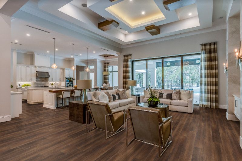A Living Room With Hardwood Floors, A Couch, Chairs, And A Large Window — Floor Coverings in Harrington, NSW