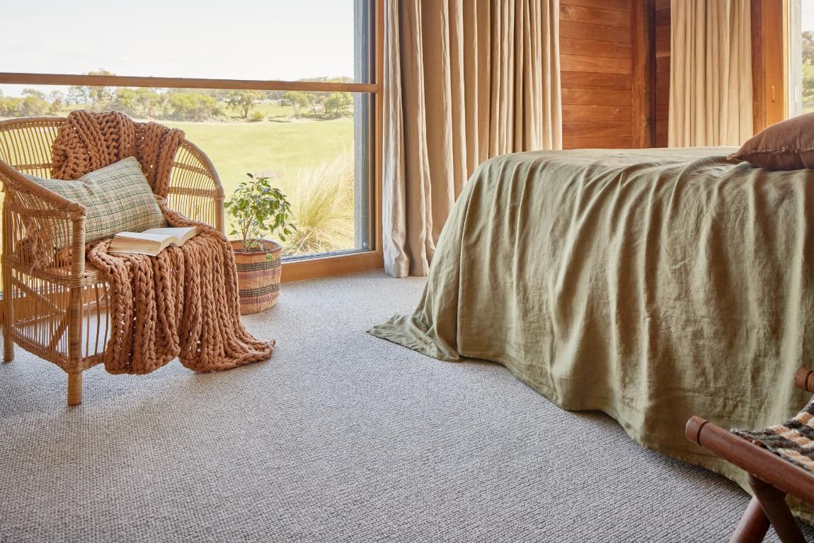 A Bedroom With A Bed, Chair, Table And Window — Flooring Suppliers in Port Macquarie, NSW