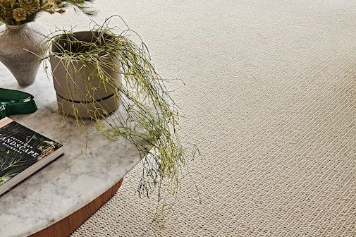 A Coffee Table With A Potted Plant And A Book On It — Floor Coverings in Kempsey, NSW