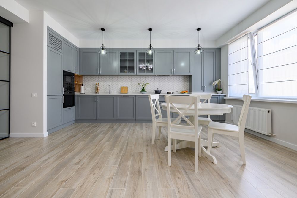 Kitchen with grey wooden furniture and white table set — Flooring Suppliers in Port Macquarie, NSW