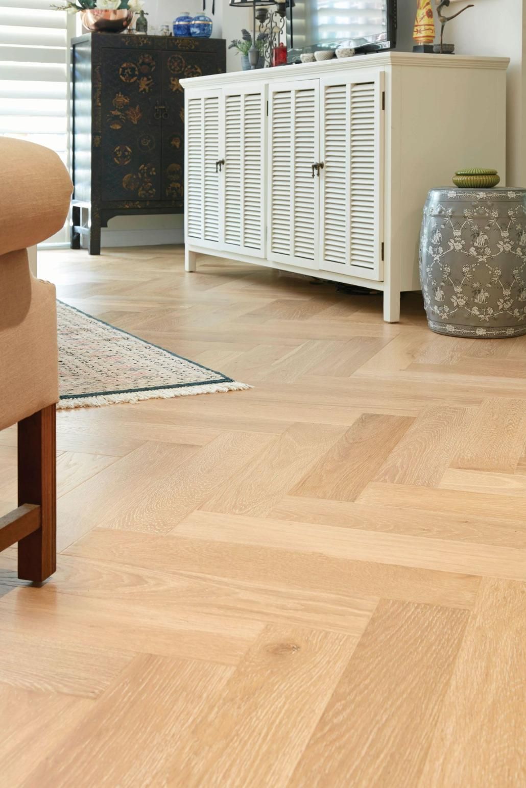 A Living Room With A Wooden Floor, A WHite Small Wardrobe, A Carpet, And A Sofa — Flooring Suppliers in Port Macquarie, NSW