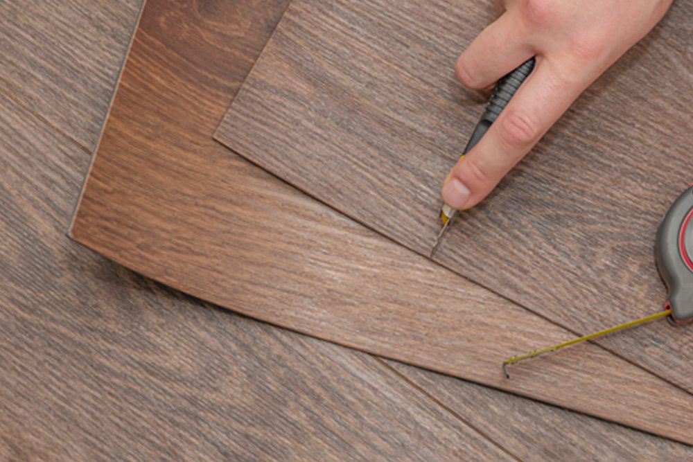 Man cutting the vinyl using cutter — Floor Coverings in Kempsey, NSW
