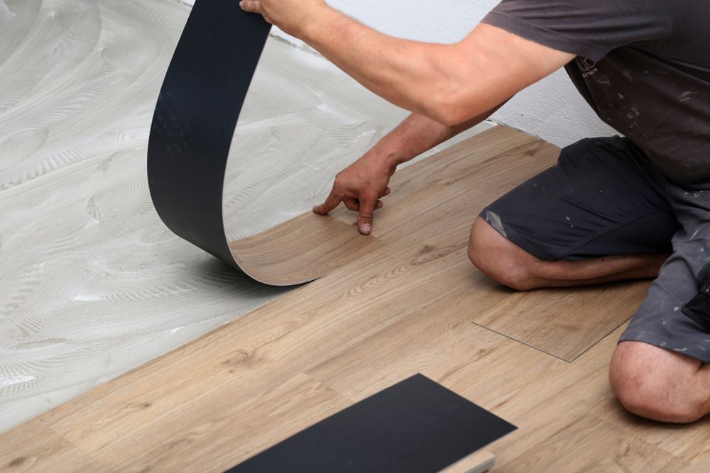 Man installing durable laminated vinyl — Floor Coverings in Kempsey, NSW