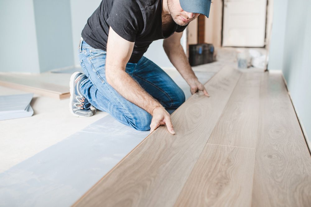 Man installing timber oak wooden flooring — Floor Coverings in Taree, NSW