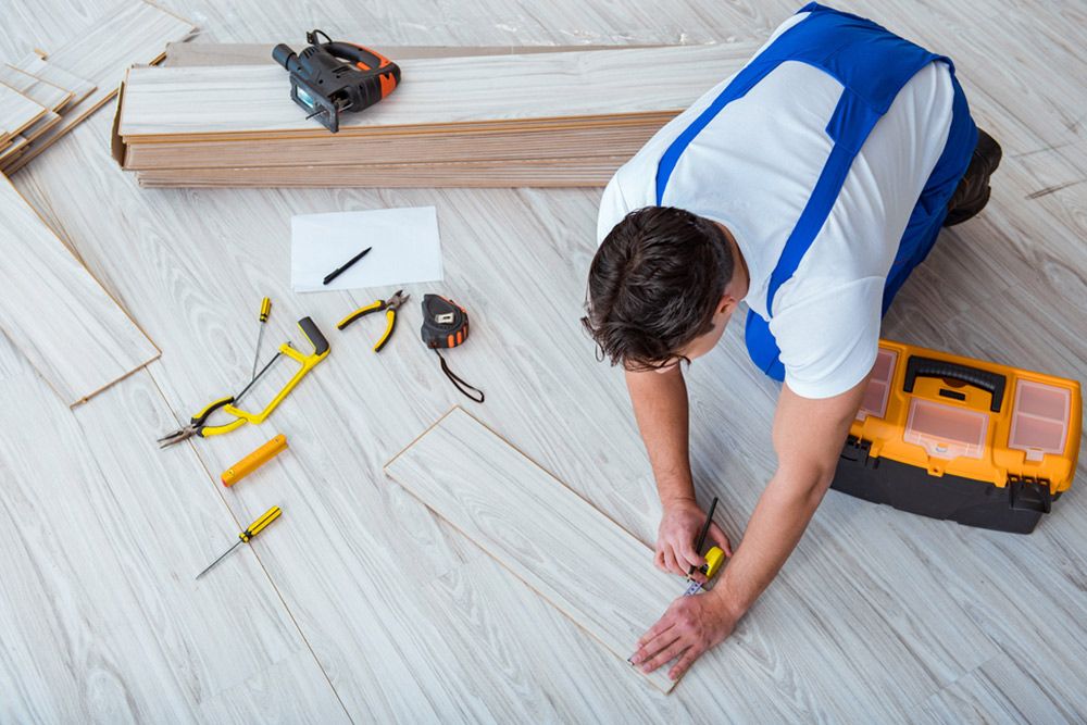 Man marking the vinyl for flooring installation — Floor Coverings in Taree, NSW