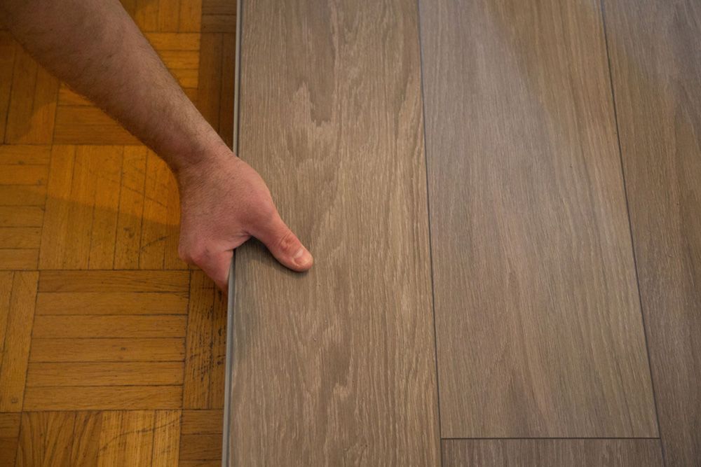 Man placing vinyl in the floor — Flooring Store Near Kempsey, NSW