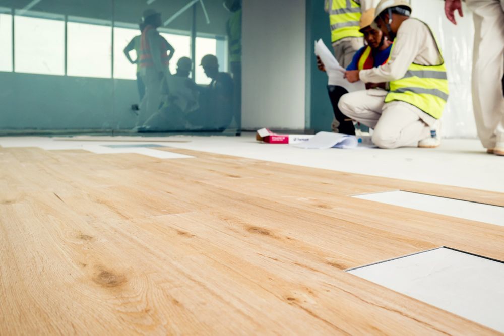 Men installing vinyl for the building — Flooring Store Near Taree, NSW