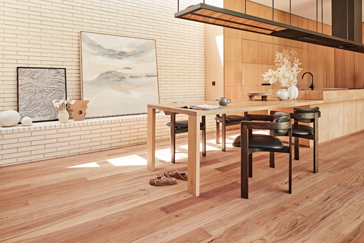 A Dining Room With A Wooden Table And Chairs And A Brick Wall — Floor Coverings in South West Rocks, NSW