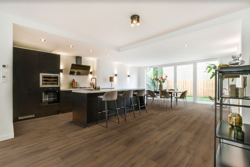 A Kitchen And Dining Room In A House With Hardwood Floors — Floor Coverings in Taree, NSW