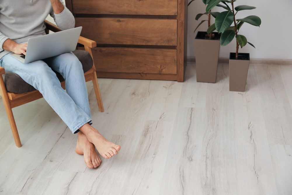 Woman using laptop while sitting in the chair — Floor Coverings in South West Rocks, NSW