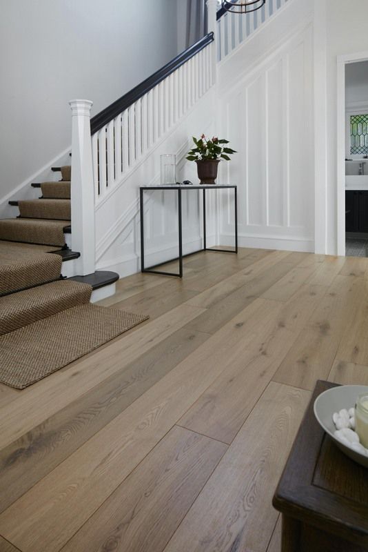 A Living Room With Hardwood Floors, Stairs And A Table — Flooring Suppliers in Port Macquarie, NSW