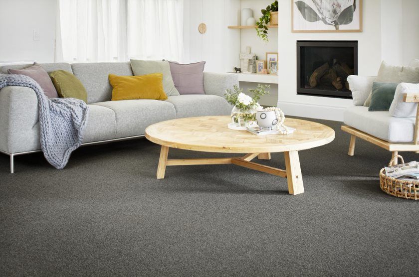 A Sofa and 5 Pillows on it with a Teapoy in front, on a Grey Floor — Flooring Suppliers in Port Macquarie, NSW