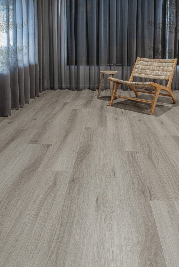 A Living Room With Hardwood Floor, a Stool, a Chair, and Curtains in Back — Flooring Suppliers in Port Macquarie, NSW