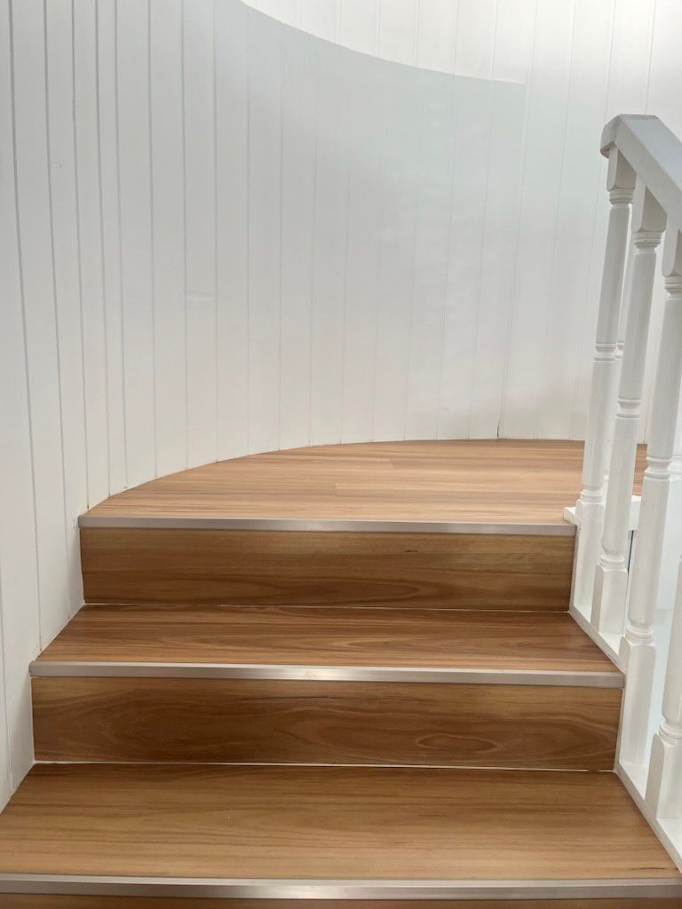 A Wooden Floor With Stairs Leading Up To It In A Room — Flooring Suppliers in Port Macquarie, NSW