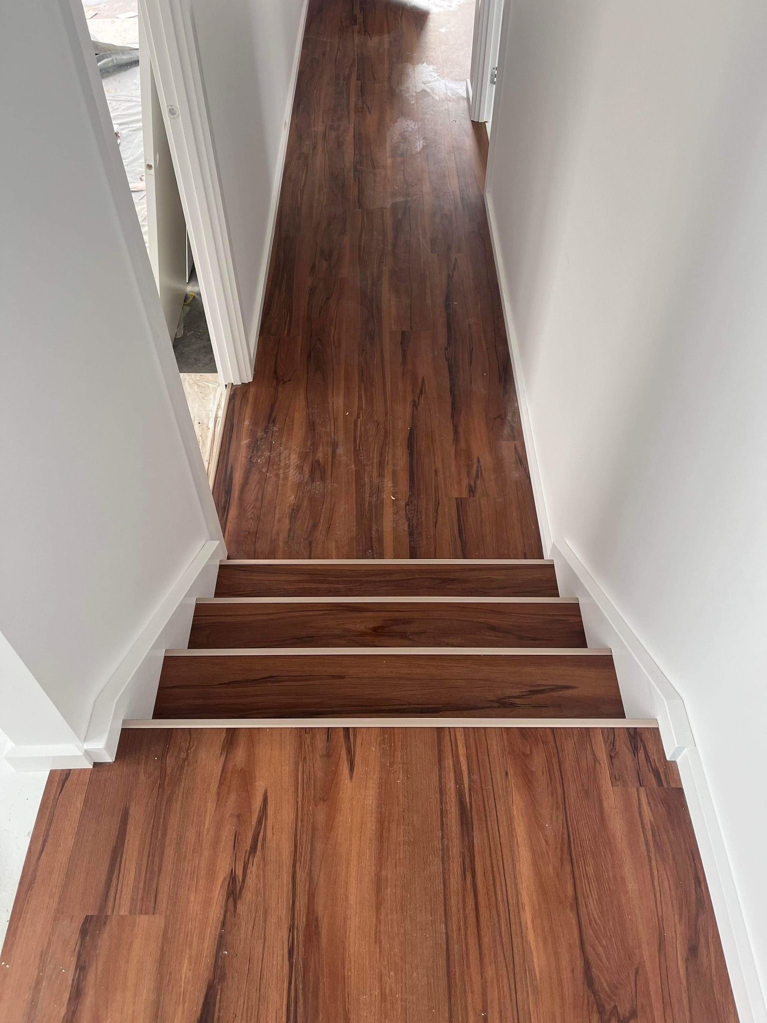 A Hallway With Wooden Floors And Stairs Leading Up To The Second Floor — Flooring Suppliers in Port Macquarie, NSW