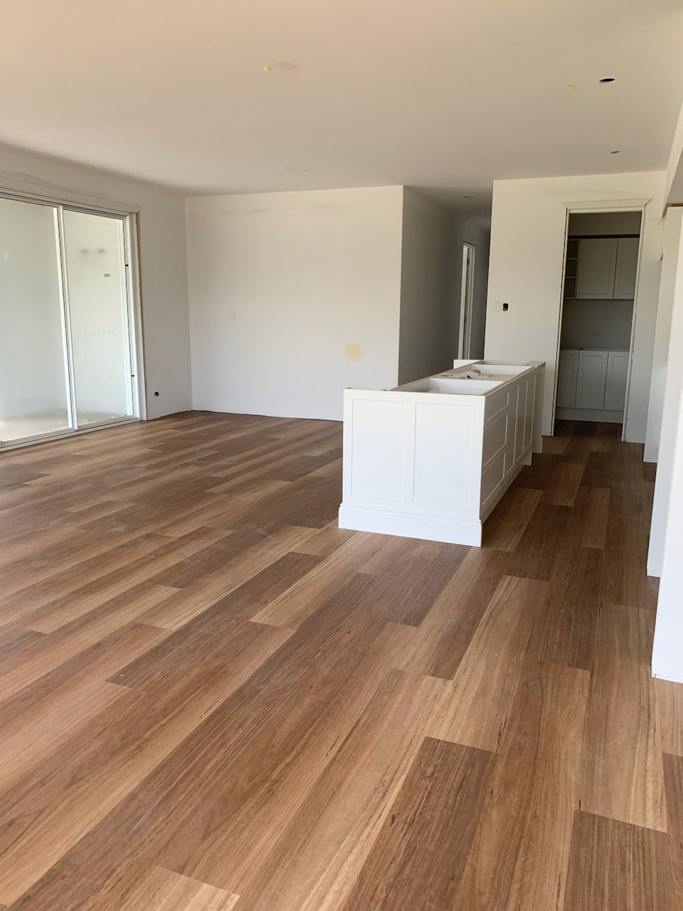 An Empty Room With A Wooden Floor And White Walls — Flooring Suppliers in Port Macquarie, NSW
